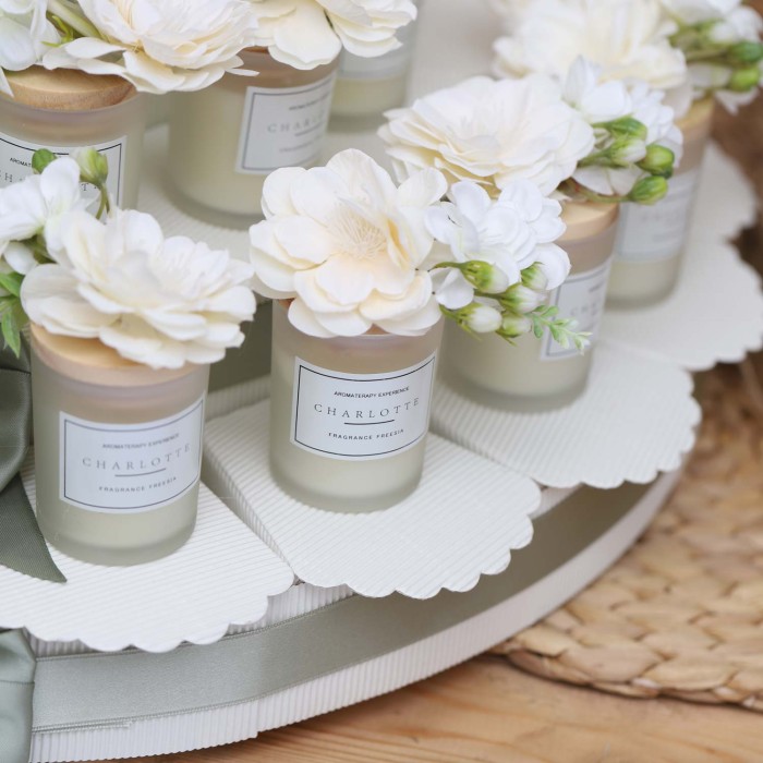 Candele in bicchiere di vetro satinato, con cera bianca profumata alla fresia e tappo in legno con bouquet