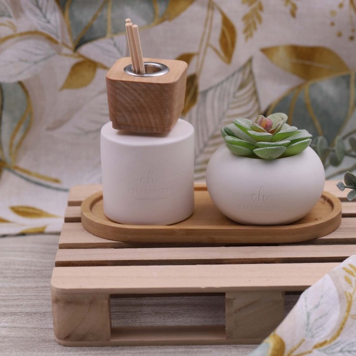 Set raffinato con piatto in legno, diffusore in porcellana bianca e piantina grassa sintetica.